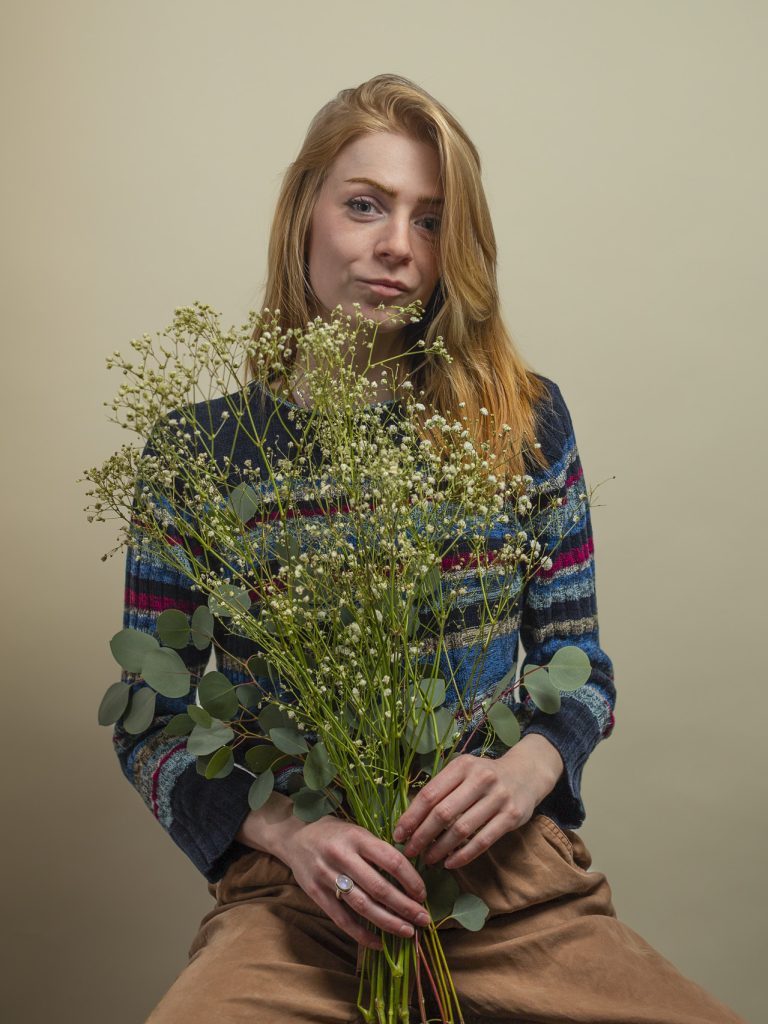 JohnaH_BrandShoot_032123_144 A blonde-haired woman holding a bouquet of baby's breath during narrative photography session